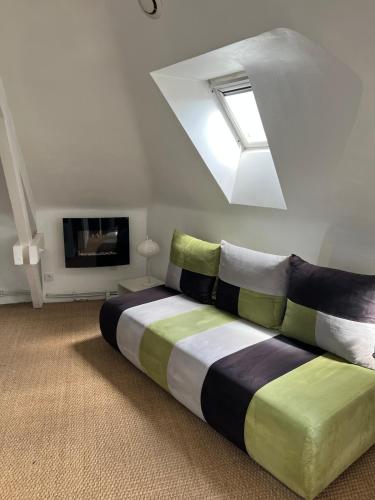une chambre avec un grand lit avec une lucarne dans l'établissement Studio au port de Vannes, à Vannes