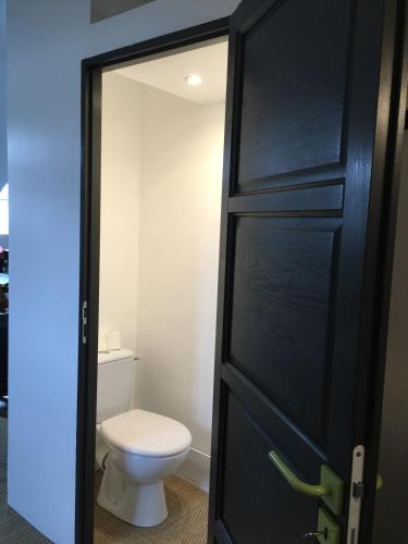 une salle de bain avec toilettes et porte noire dans l'établissement Studio au port de Vannes, à Vannes