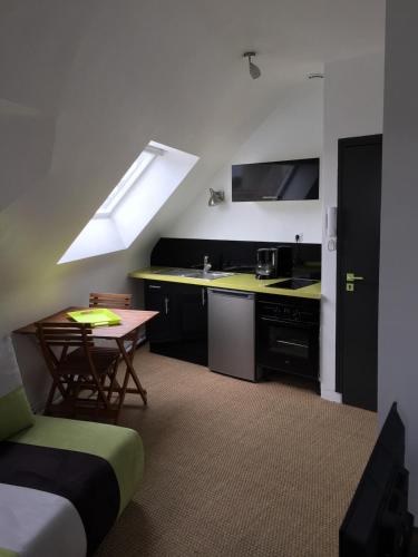 Cette chambre comprend une cuisine avec un évier et une table. dans l'établissement Studio au port de Vannes, à Vannes