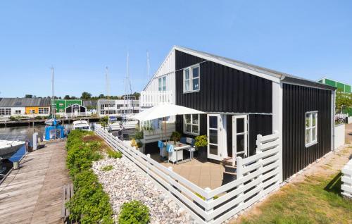 a black and white house with a deck and a building at Krebsen 617 in Ebeltoft
