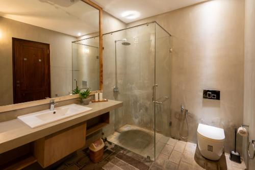 a bathroom with a sink and a glass shower at Villa de Jojo in Galle