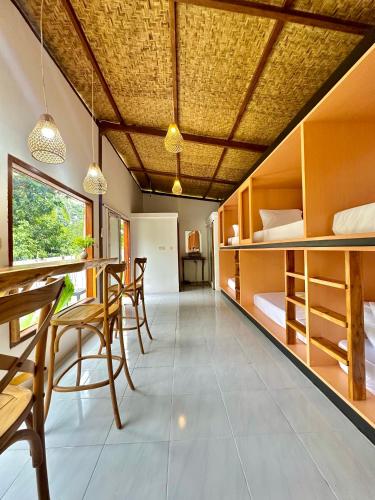 a room with a bed and a table and chairs at Kelapa Lodge - Lombok - in Senggigi 