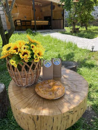 a table with a pizza and a basket of flowers at Eco House in Odzun