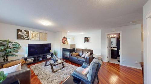 a living room with couches and a flat screen tv at Cozy comfy and relaxing home at Cougaridge SW Calgary in Calgary