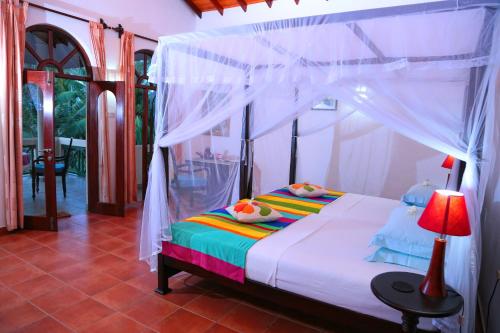 1 dormitorio con 1 cama con dosel en Shangri-lanka Villa, en Bentota