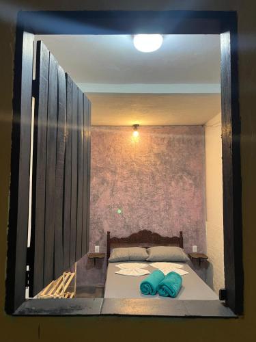 a bedroom with a bed with two blue pillows on it at Casa Mandala Coliving in Lençóis