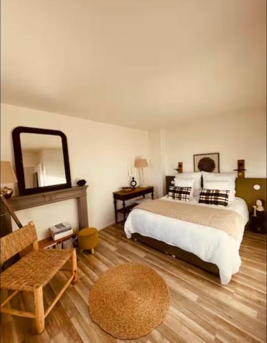 une chambre avec un lit, une chaise et un miroir dans l'établissement Gisèle a plage, à Rivedoux-Plage