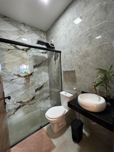 a bathroom with a toilet and a shower and a sink at Chalés Refúgio da Sil 2 in Cavalcante