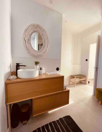 une salle de bain avec un lavabo et un miroir dans l'établissement Gisèle a plage, à Rivedoux-Plage