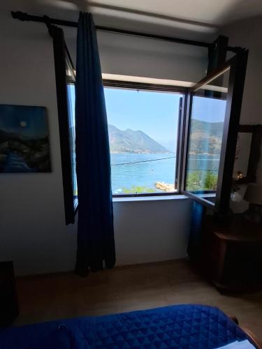 a bedroom with a window with a view of the ocean at Joković Accommodation in Kotor