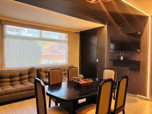 a living room with a table and a couch at Depa Frente al aeropuerto hasta 12 Huéspedes in Mexico City