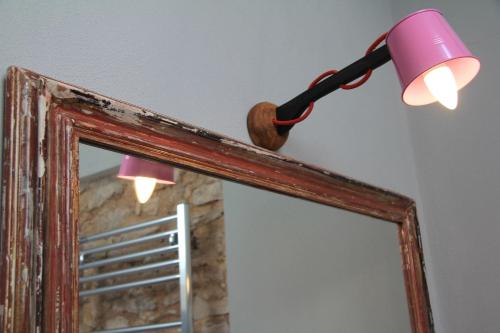 a pink lamp on top of a mirror at Pekko in Spello