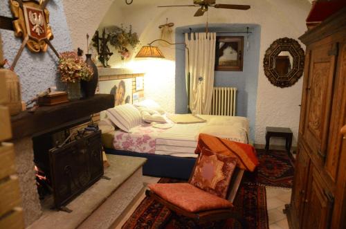 a bedroom with a bed and a chair and a fireplace at B&B Villa Moro - Family House in Domodossola