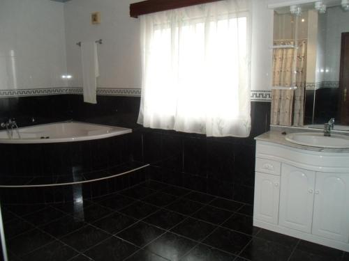 uma casa de banho com uma banheira, um lavatório e uma janela em Tropical Fruit Garden em Velas