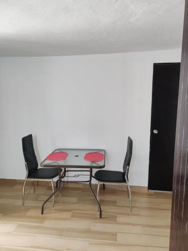 a table and two chairs in a room at Departamento privado, amplio, Chetumal, Q. Roo in Chetumal