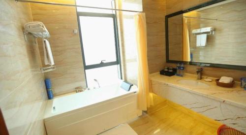 a bathroom with a tub and a sink and a window at Auspicious Hotel in Zhongshan
