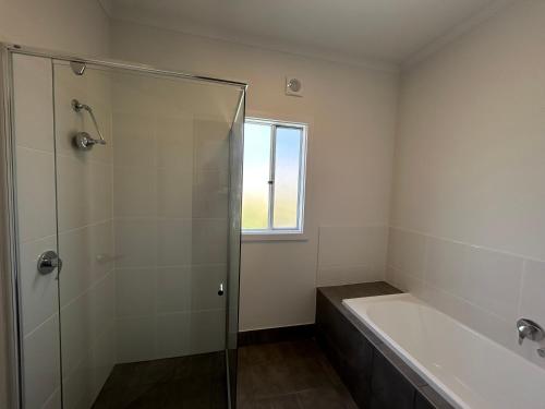 a bathroom with a shower and a bath tub at Mood Beach House - Moonta Bay in Port Moonta