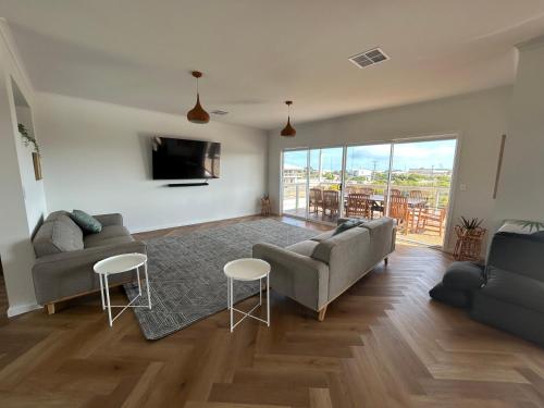 a living room with two couches and a tv at Mood Beach House - Moonta Bay in Port Moonta