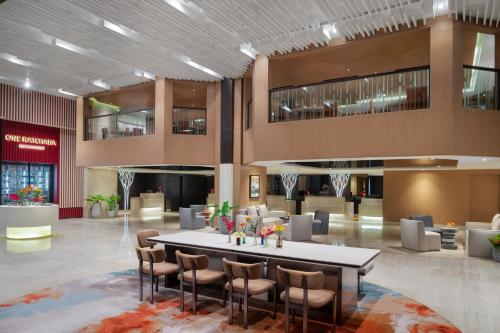 a lobby with a table and chairs in a building at Avani Ratchada Bangkok Hotel in Bangkok