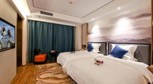 a hotel room with two large white beds in it at East Queen Hotel (Xi'an Beimen Metro Station) in Xi'an