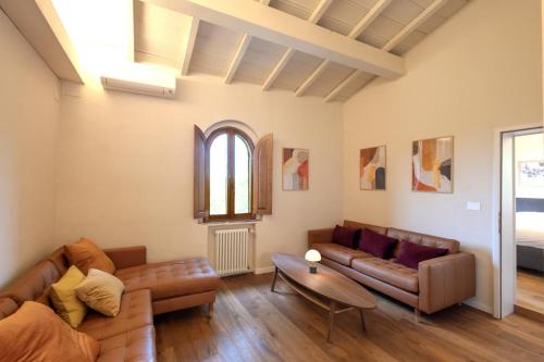a living room with two couches and a table at Your Tuscan Hideaway at Le Pietre Vive in Castelnuovo Berardenga