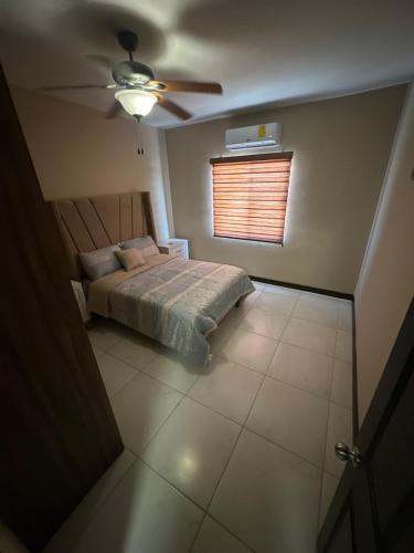 a bedroom with a bed and a ceiling fan at House in a private residential development in Delicias