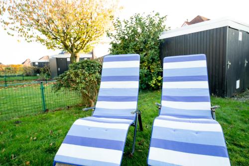 two blue and white chairs sitting in the grass at Babsi`s Möwennest in Schillig