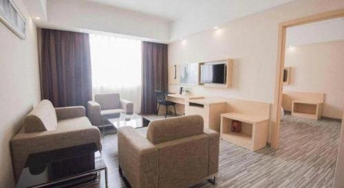 a living room with a couch and a chair in a room at City Comfort Inn Shantou Daxue Road in Shantou