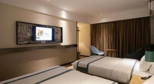 a hotel room with two beds and a flat screen tv at City Comfort Inn Beiliu Yongfeng Plaza Chengnan Bus Station in Yulin