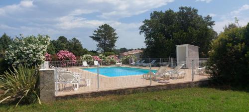 une piscine entourée de chaises et d'une clôture. dans l'établissement Residence Riviera, à Porto-Vecchio