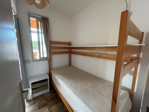 une petite chambre avec deux lits superposés et une fenêtre dans l'établissement Appartement mezzanine 4 couchages - FR-1-837-21, à Argelès-sur-Mer