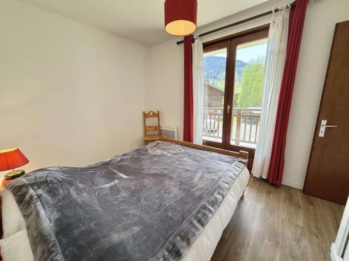 une chambre avec un grand lit et une grande fenêtre dans l'établissement Appartement 2 chambres à Praz-Sur-Arly avec parking - FR-1-603-125, à Praz-sur-Arly