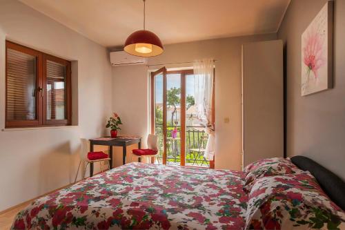 een slaapkamer met een bed, een raam en een tafel bij Ava apartmani in Zablaće