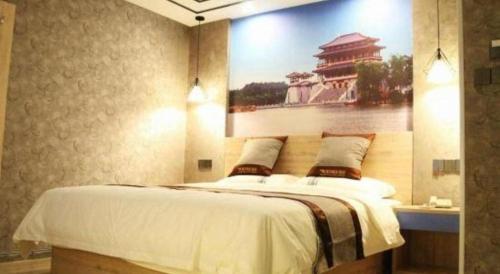 a bedroom with a large bed with a painting on the wall at City 118 Selected Hotel Xi'an Fengcheng Nan Road in Xi'an