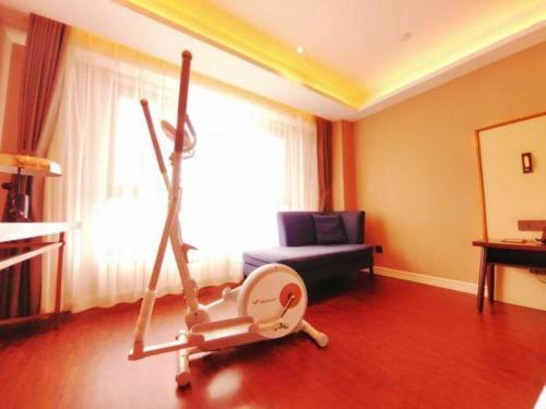 a living room with a room with a exercise bike at James Joyce Coffetel Harbin West High-speed Railway Station Wanda Plaza in Harbin