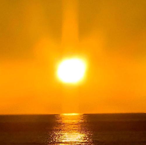 a sunset over the ocean with the sun in the sky at Super Pilgrimage Inn Karyogo A Private Retreat Just for You in Nahari