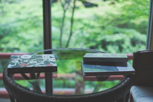a table with a laptop sitting on top of a chair at こもれびの宿 明徳庵 in Minoo