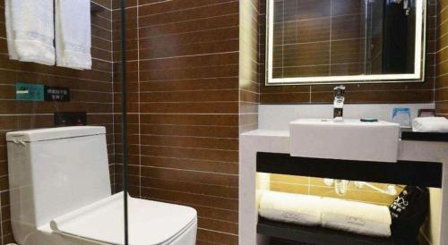 a bathroom with a white toilet and a sink at Xana Hotelle Xi'an Zhonglou, Huimin Street Metro Station in Xi'an