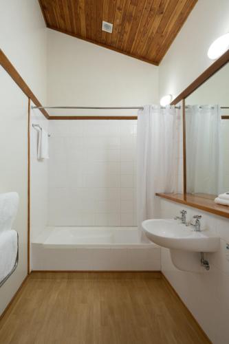 a bathroom with a white tub and a sink at Riverside Hotel Marlborough in Blenheim