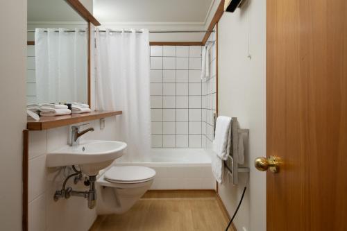 a bathroom with a toilet and a sink and a tub at Riverside Hotel Marlborough in Blenheim