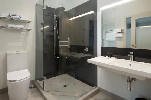 a bathroom with two sinks and a glass shower at Riverside Hotel Marlborough in Blenheim
