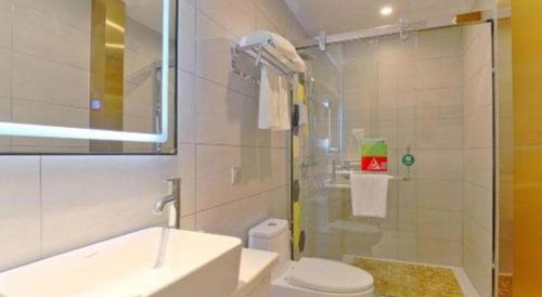a bathroom with a shower and a toilet and a sink at Vatica Hotel Hefei Yaohai Longgang Subway Station in Hefei