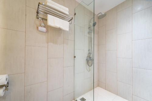 a bathroom with a shower with a glass door at Novus Sol Hotel & Apartment Sunset Town Phu Quoc in Phu Quoc