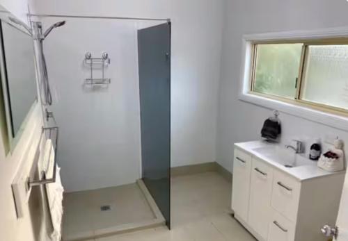 a bathroom with a shower and a sink at Miners' cottage in Broken Hill