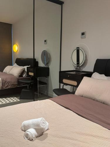 a bedroom with two beds and a vanity and a mirror at Mel Stylish living in Melbourne