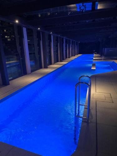 a swimming pool with blue water in a building at Mel Stylish living in Melbourne