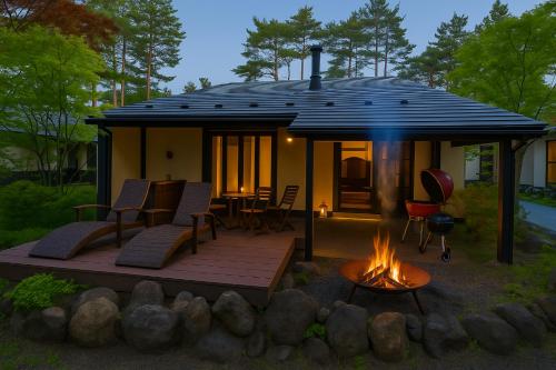 a house with a deck and a fire pit at HANZ OUTDOOR RESORT -formerly GLAMPING VILLA HANZ KAWAGUCHIKO in Fujikawaguchiko