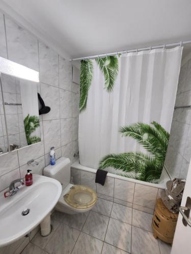a bathroom with a toilet and a shower curtain with a plant at 2 Zimmer 60m2 an der Talstation Jakobshorn, 10 min walk to WEF in Davos