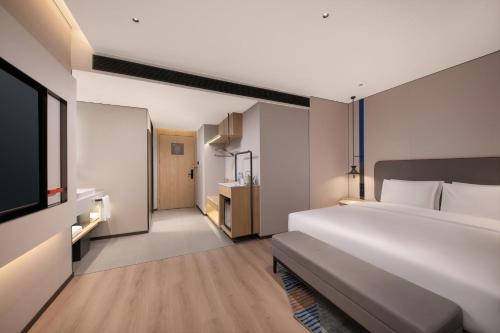 a bedroom with a large white bed and a television at Holiday Inn Express Wuhan Jianghan Road by IHG in Wuhan