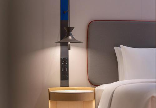 a bedroom with a bed and a mirror and a table at Holiday Inn Express Wuhan Jianghan Road by IHG in Wuhan